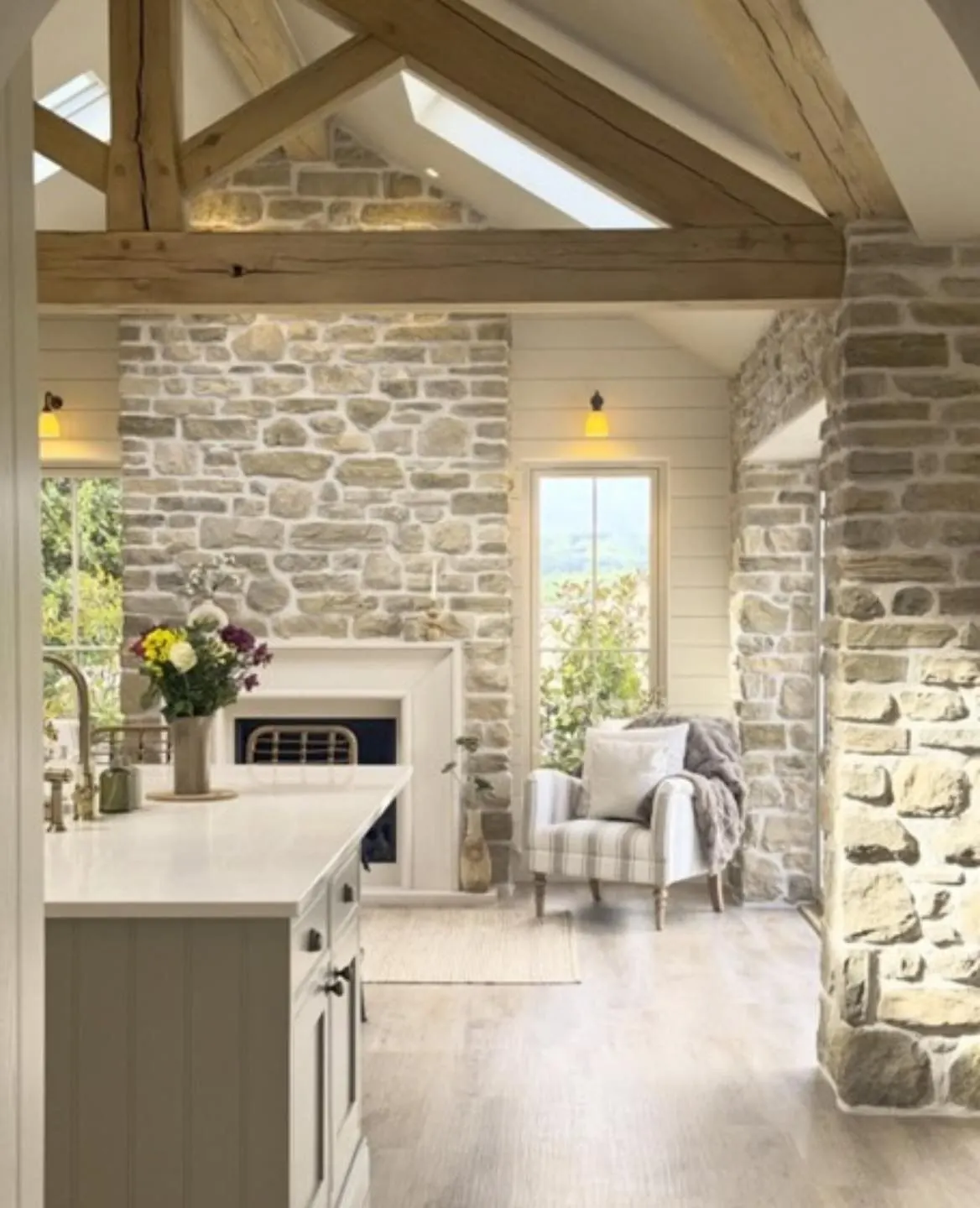 Pale stone walling and exposed timber beams in a bright interior