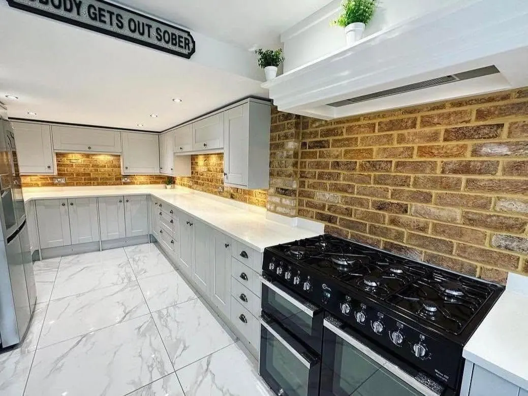 Warm brick slip splashback and worktop wall in a light kitchen