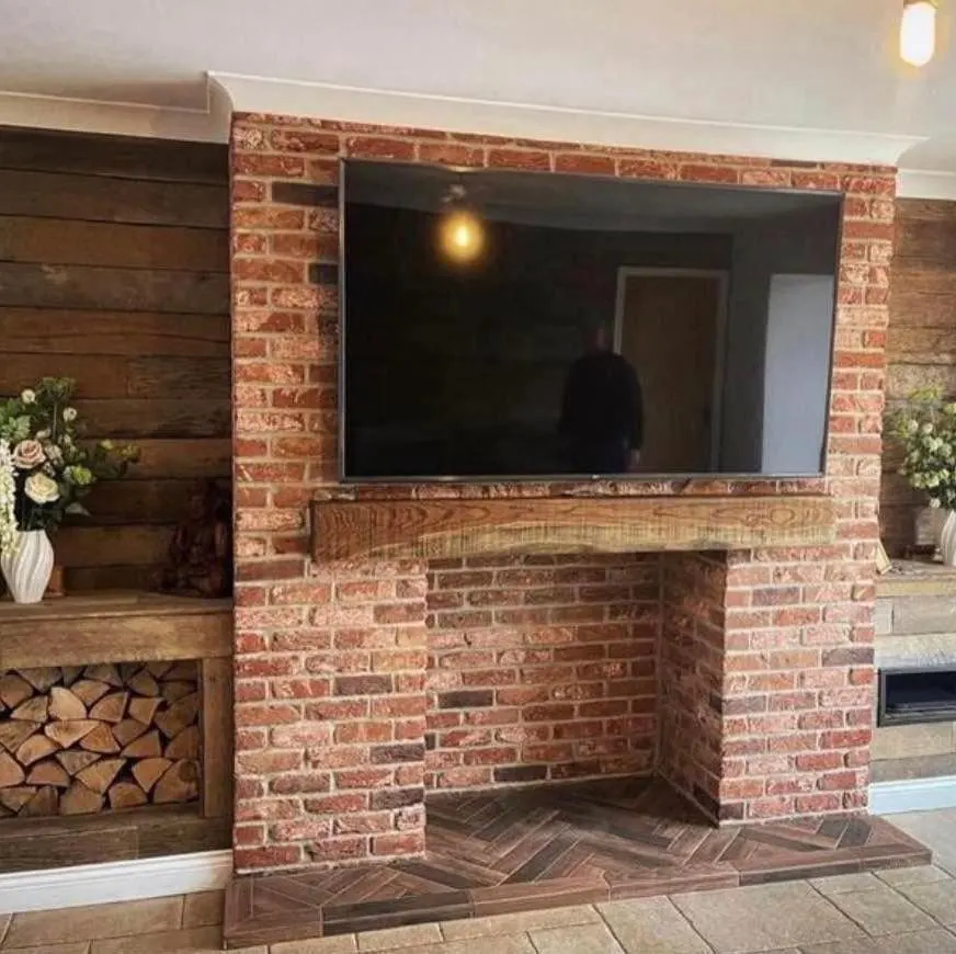 Red brick slip media wall and fireplace surround