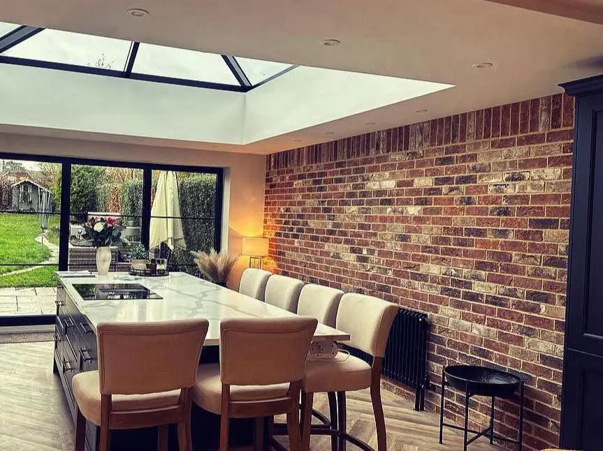 Dark red brick slip feature wall in a kitchen diner