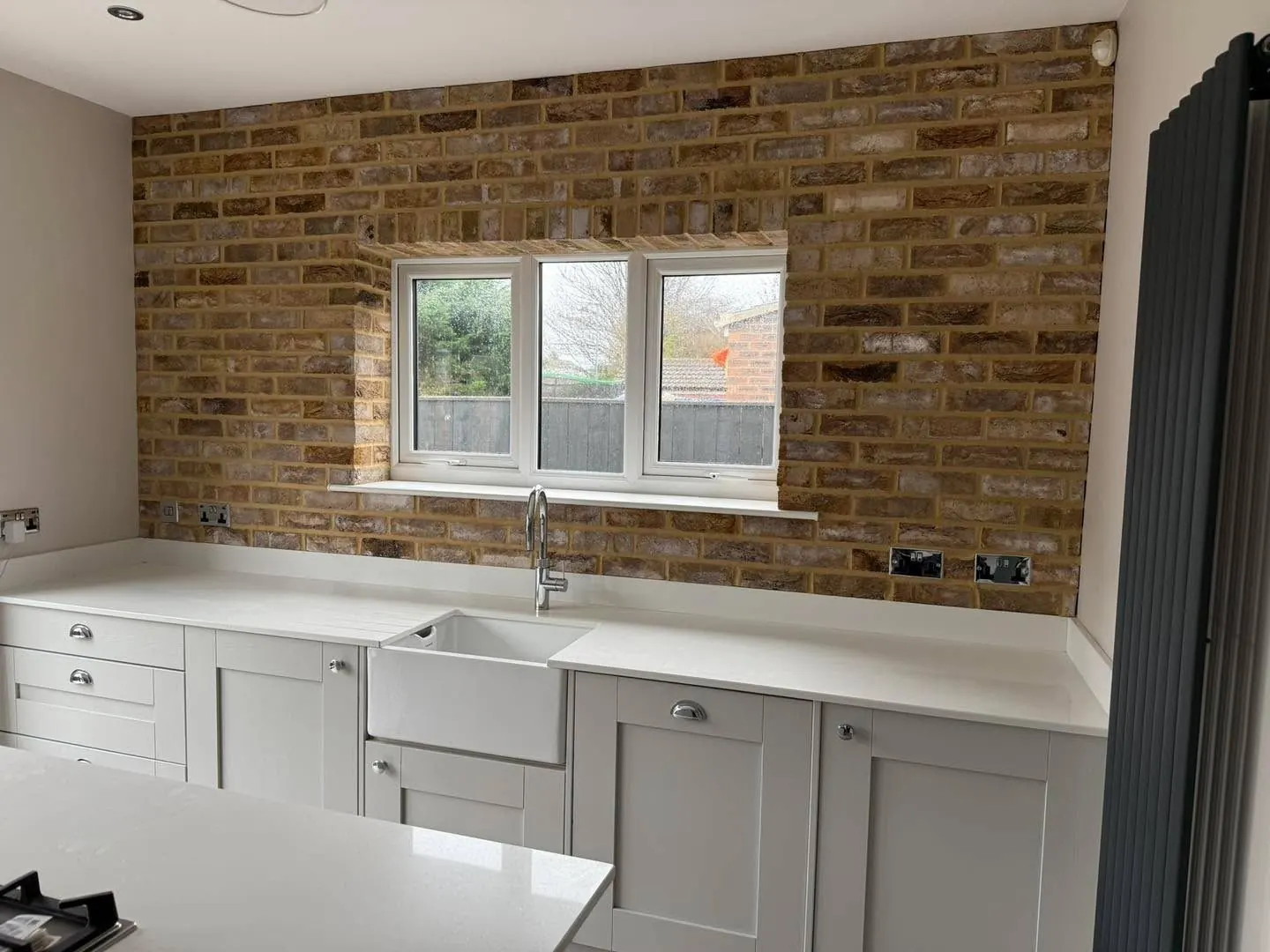 Full wall of pale buff brick slips fitted in a kitchen, showing a brick slip finish available to view as a sample