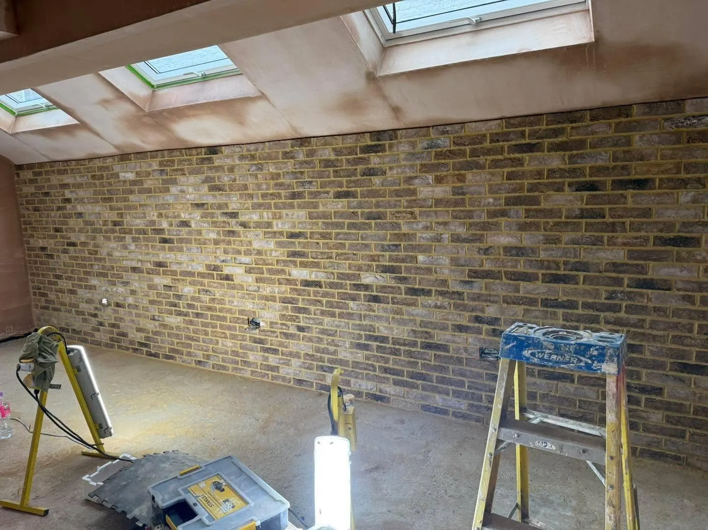 Large interior brick slip wall part-way through installation