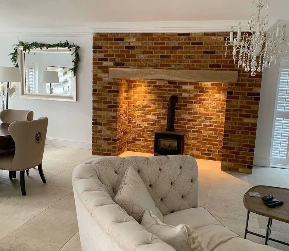 Red brick slip chimney breast and fireplace recess with a wood burner